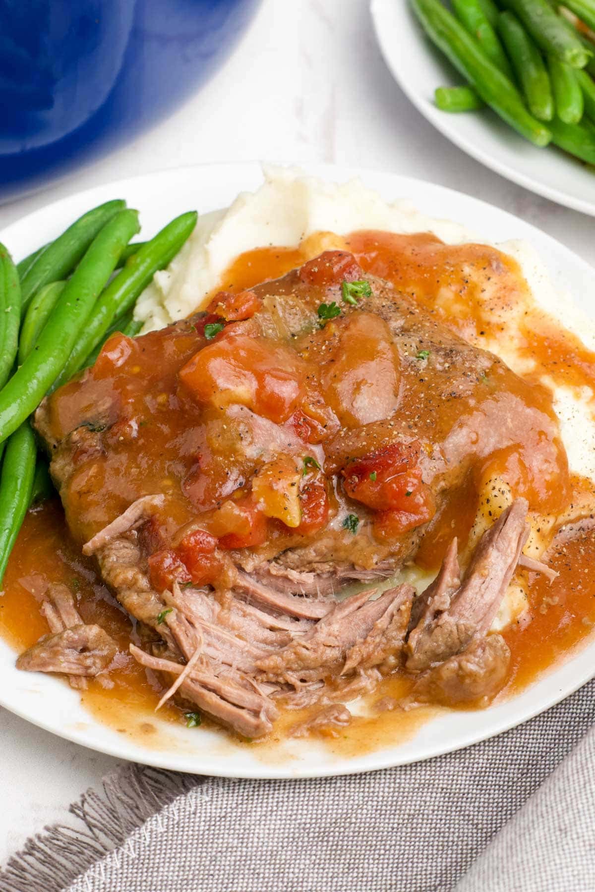 Steaks in tomato gravy with mashed potatoes and green beans.