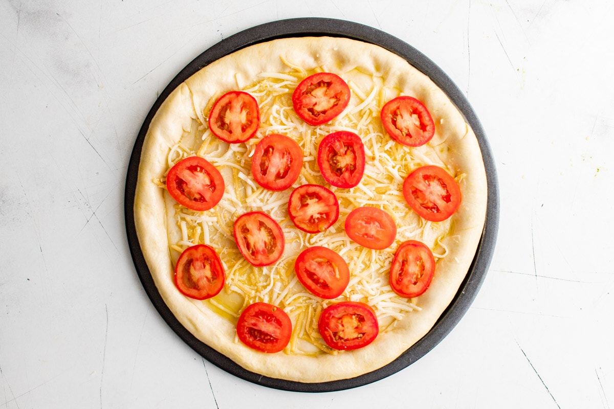 Garlic oil, tomatoe and cheese on top of the crust.