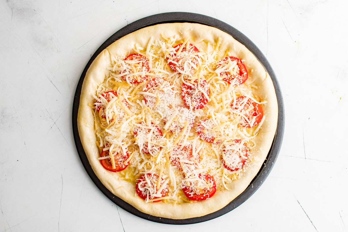 cheese and tomatoes on top of pizza.