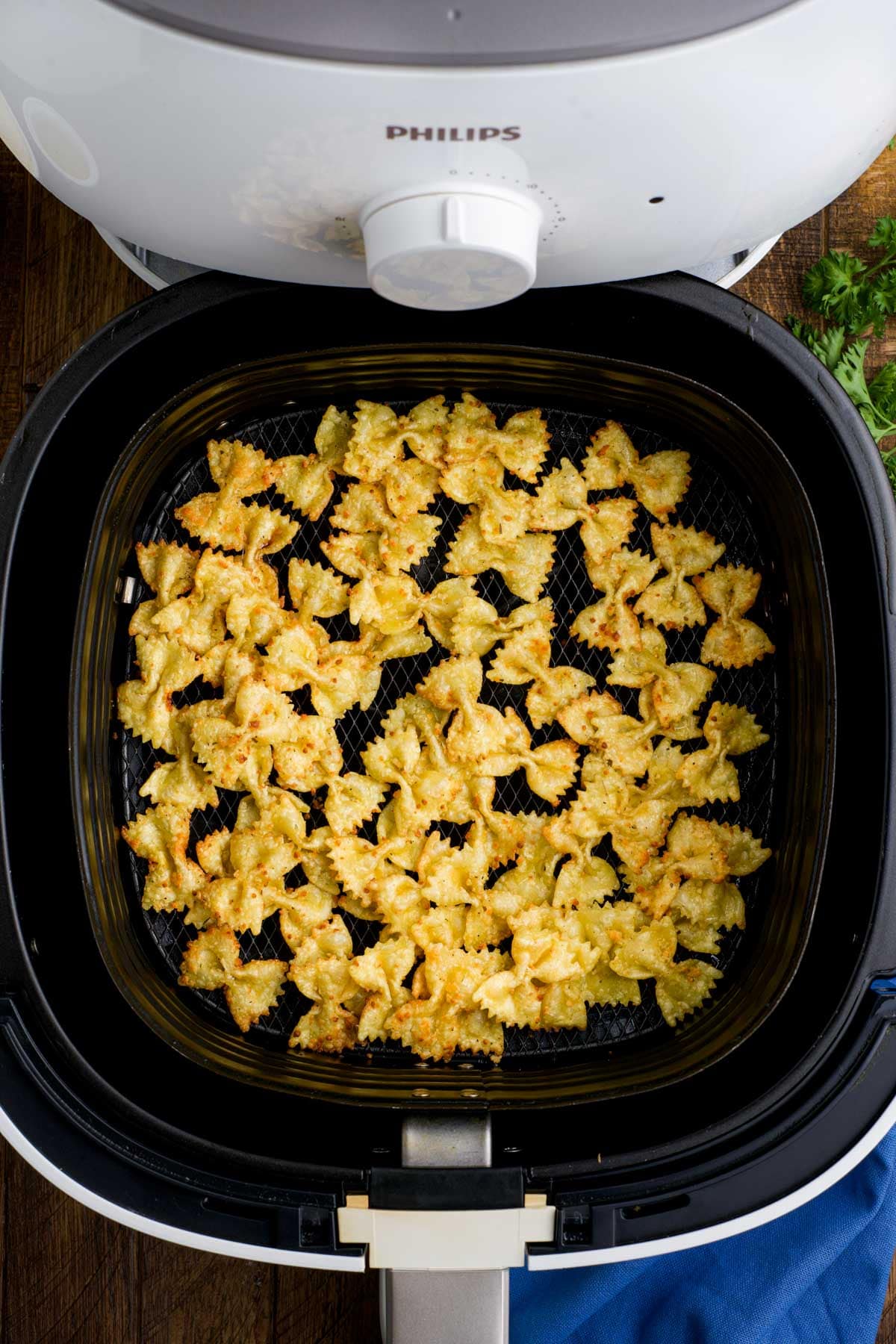 Air fryer basket with crispy pasta chips.