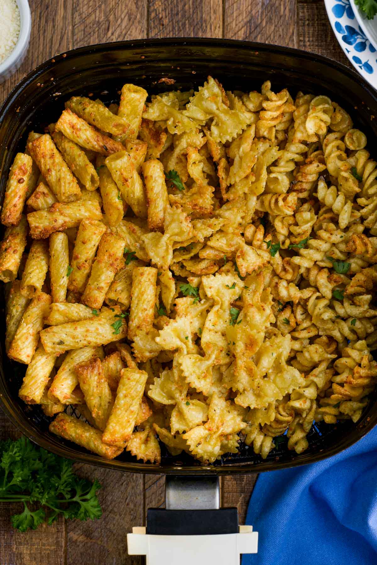 Air fryer basket with fried pasta chips.