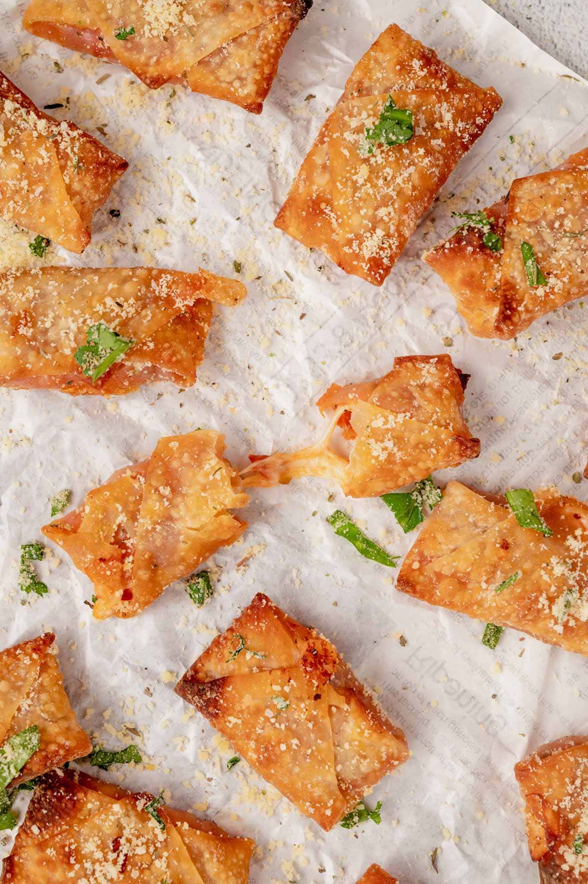 Homemade pizza rolls on a white parchment paper.