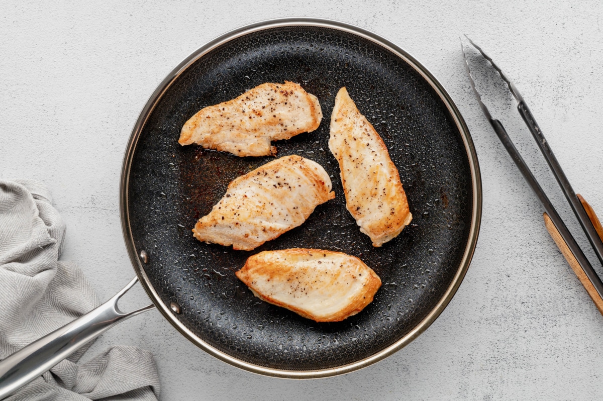 Cooked chicken breasts in a skillet.