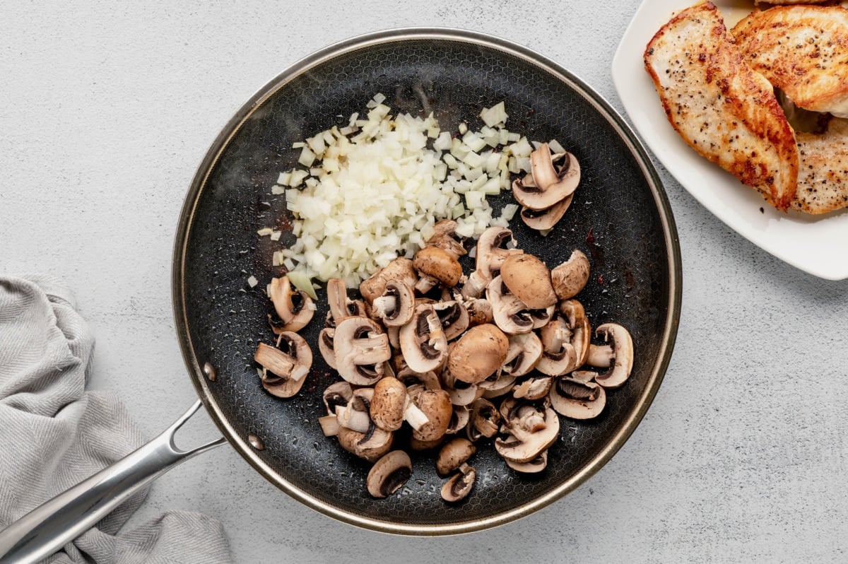 Onions and mushrooms in a skillet.