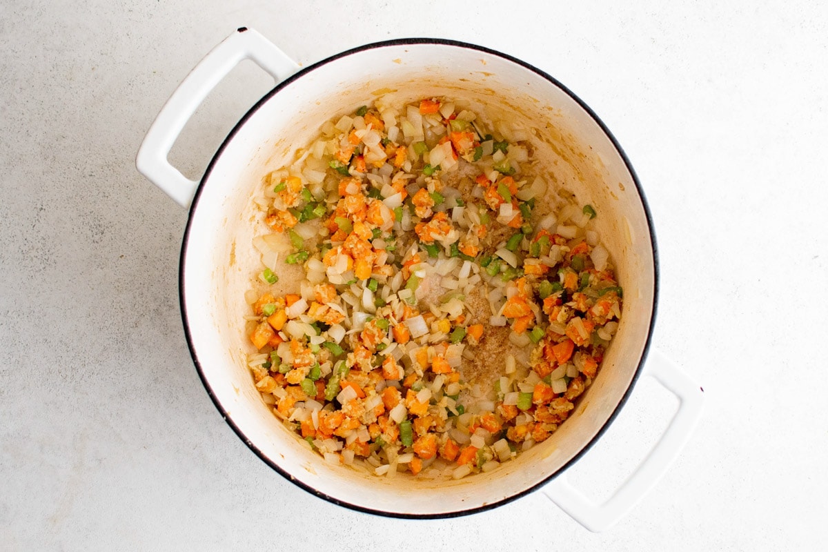 Carrots, onion and celery cooking with flour in a soup pot.