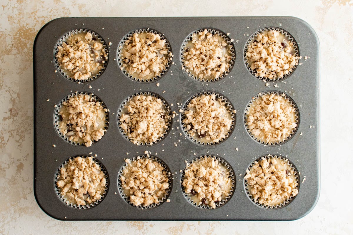 Muffin batter in a pan with crumb topping.