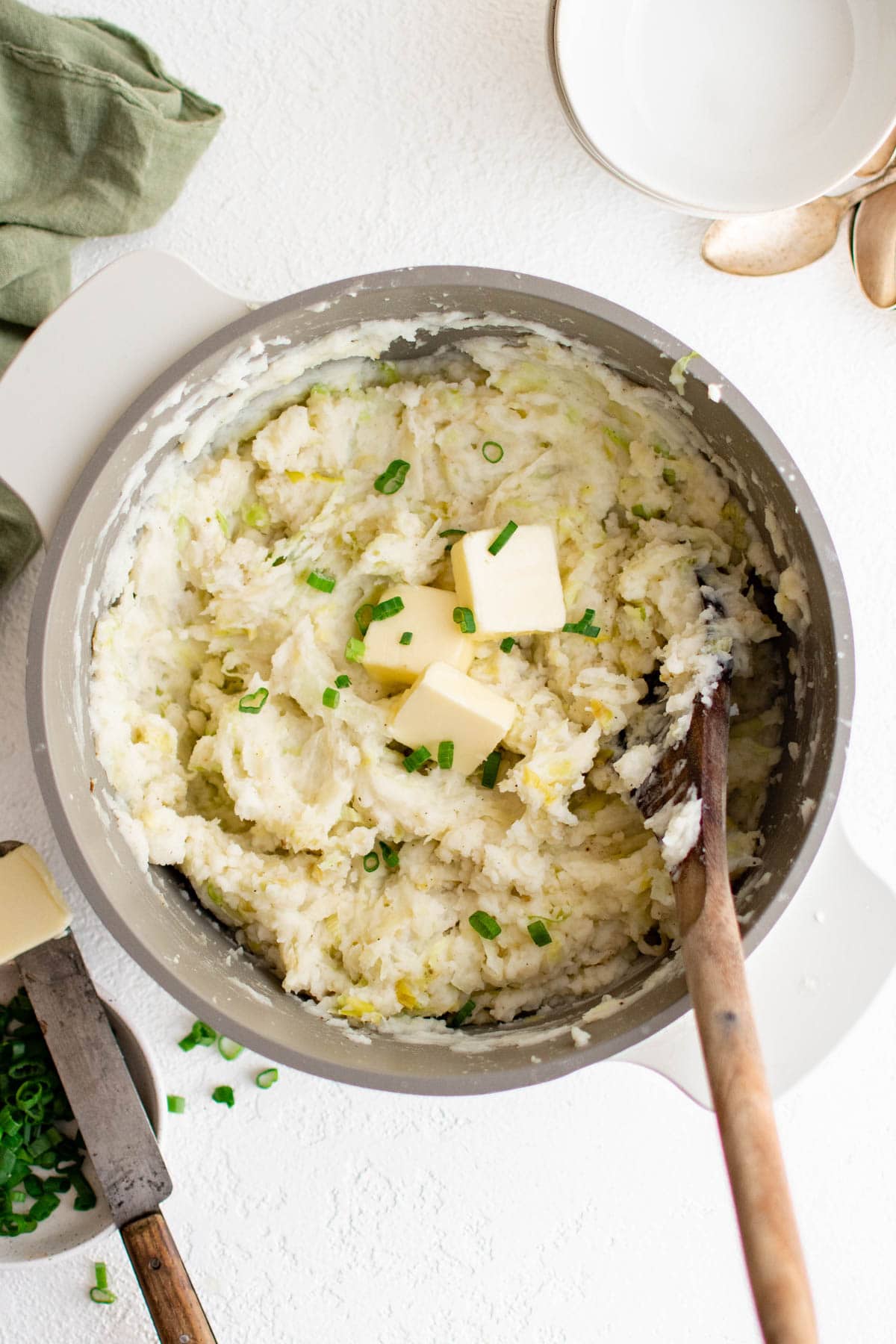 Mashed potatoes with cabbage in a bowl with a spoon.