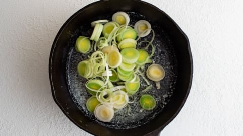 Sliced leeks in a large skillet.