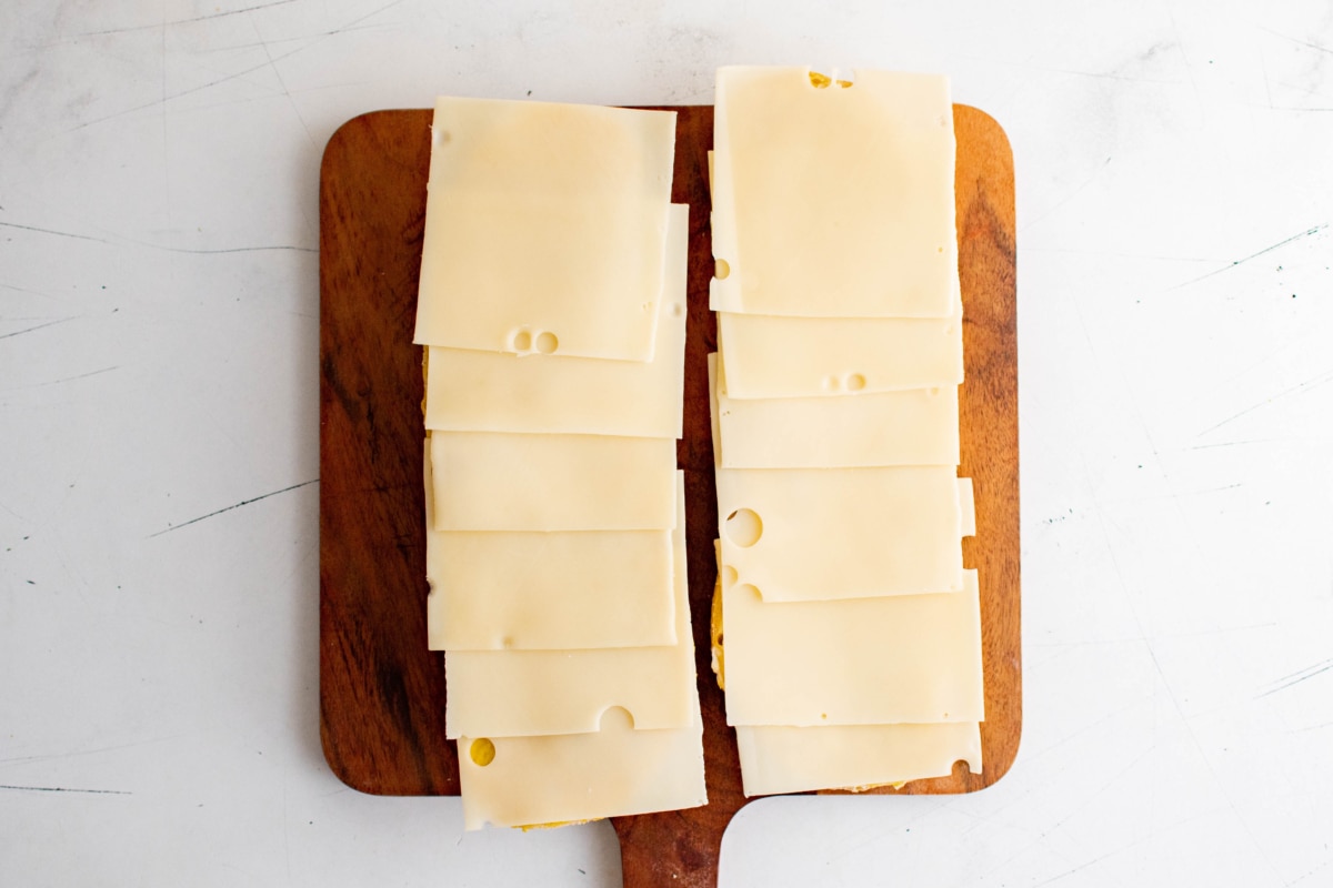 Whole bread loaf halves with slices of cheese.