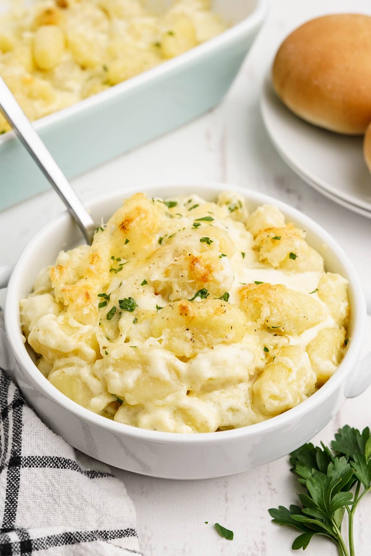 Bowl of gnocchi alfredo with a spoon.