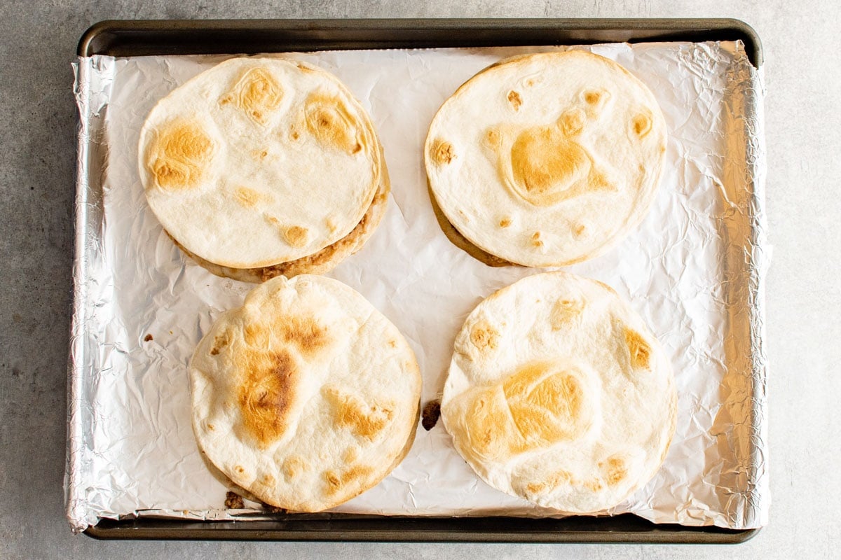 Crispy tortilla on a foil covered baking sheet. 