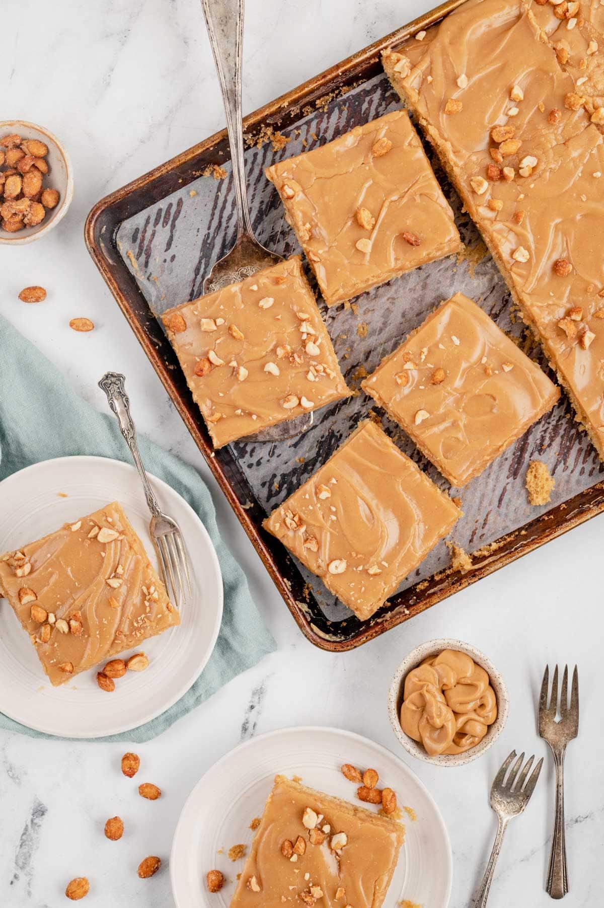 Peanut butter sheet cake in squares on a sheet pan.