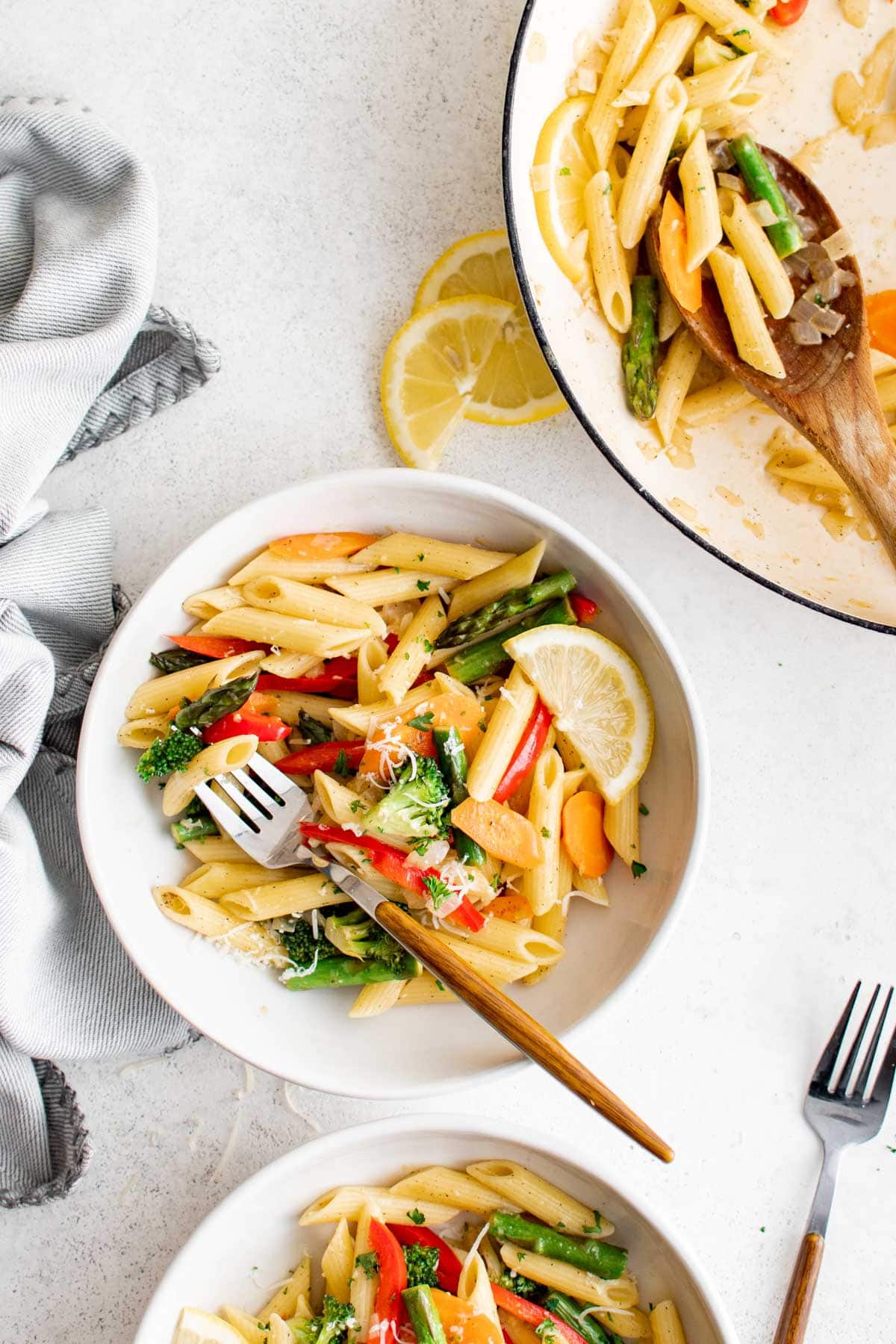 Plates with penne pasta nad veggies.