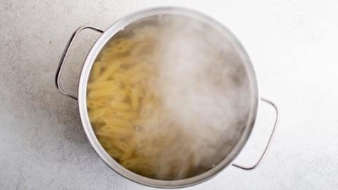 Penne pasta boiling in a large pot.