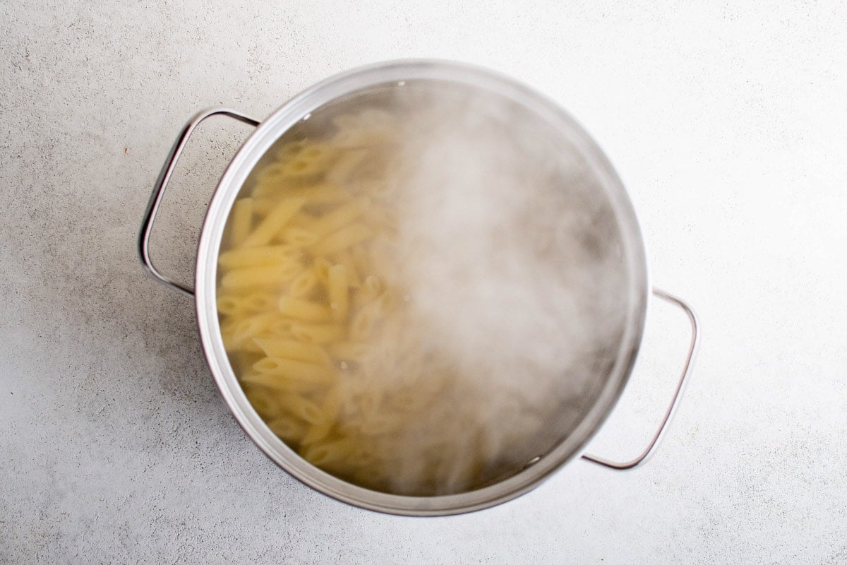 Penne pasta boiling in a large pot.
