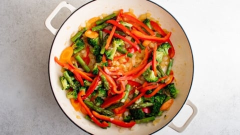 Cooked vegetables and garlic in a skillet.
