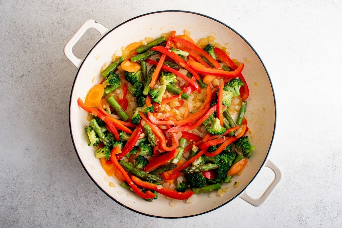 Cooked vegetables and garlic in a skillet.