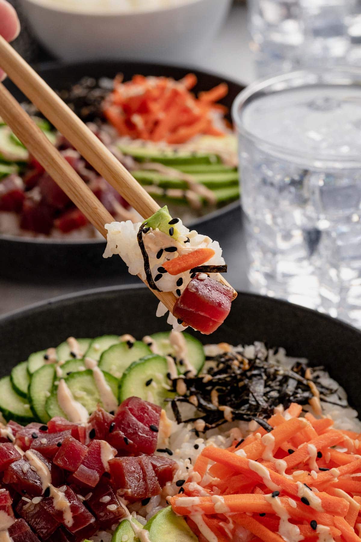 Sushi bowl, with chopsticks.