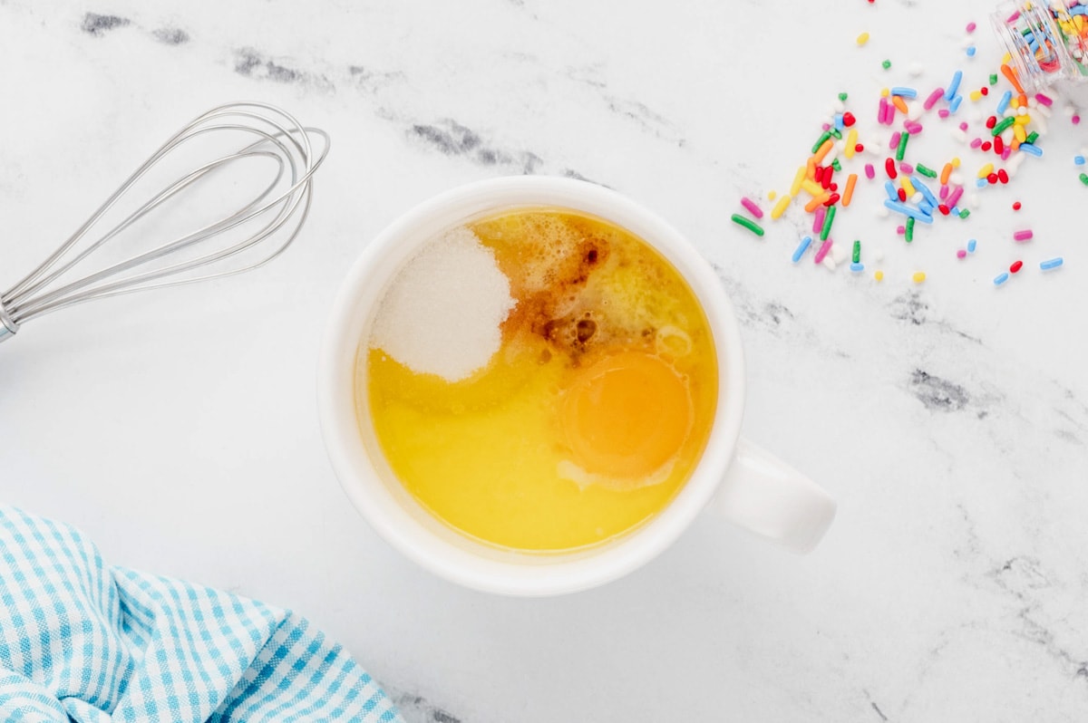 Melted butter, egg yolk, sugar in a mug.