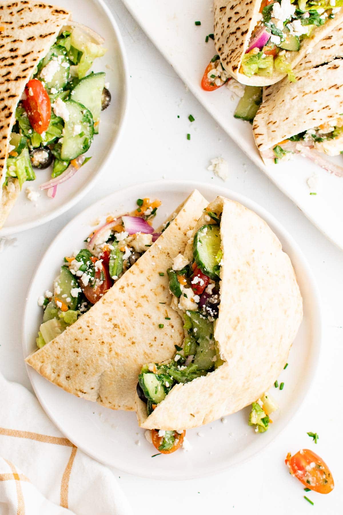 Pita Sandwiches with veggies on a white plate.