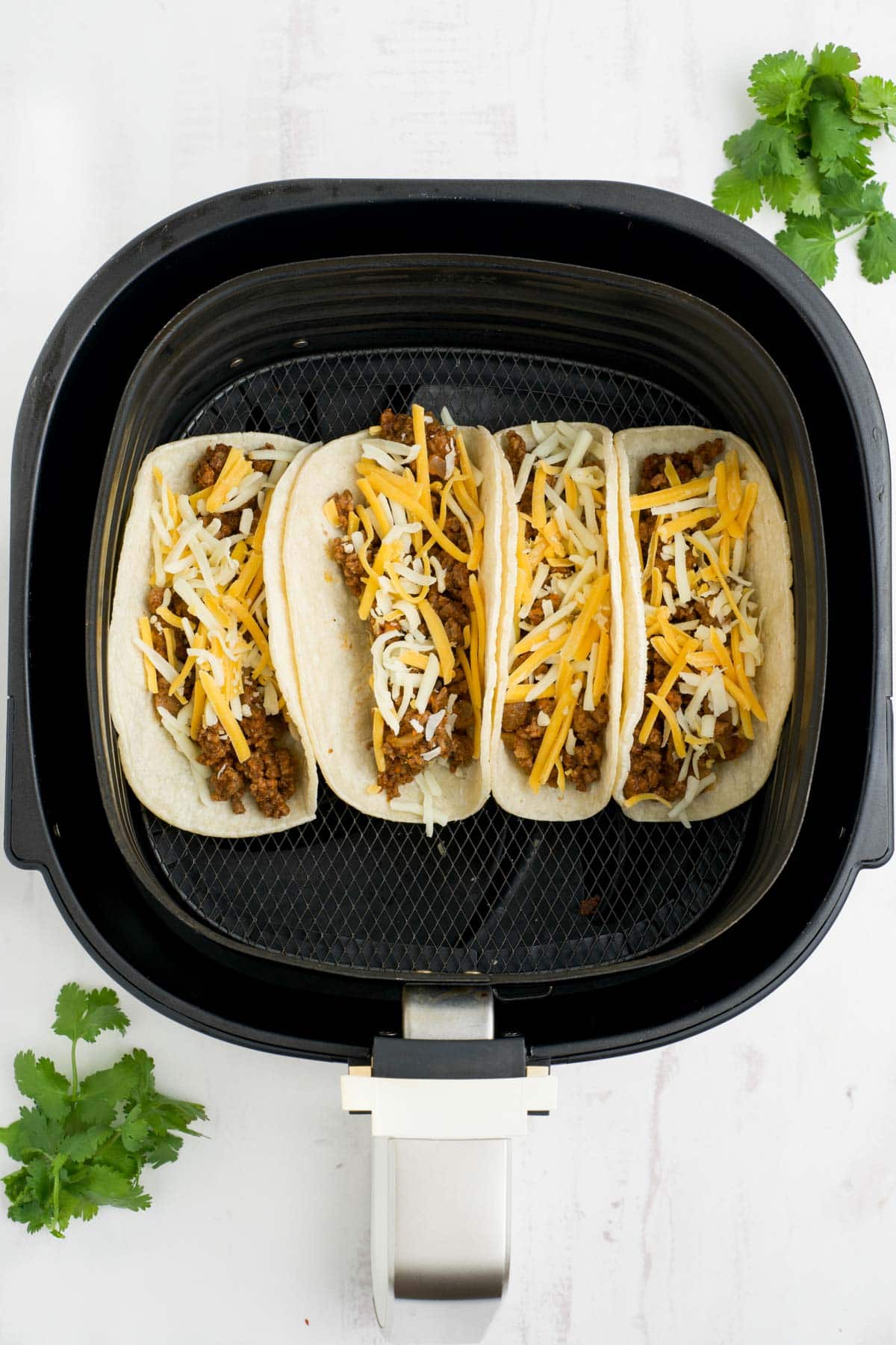 Corn tortillas with ground beef and cheese in an air fryer.