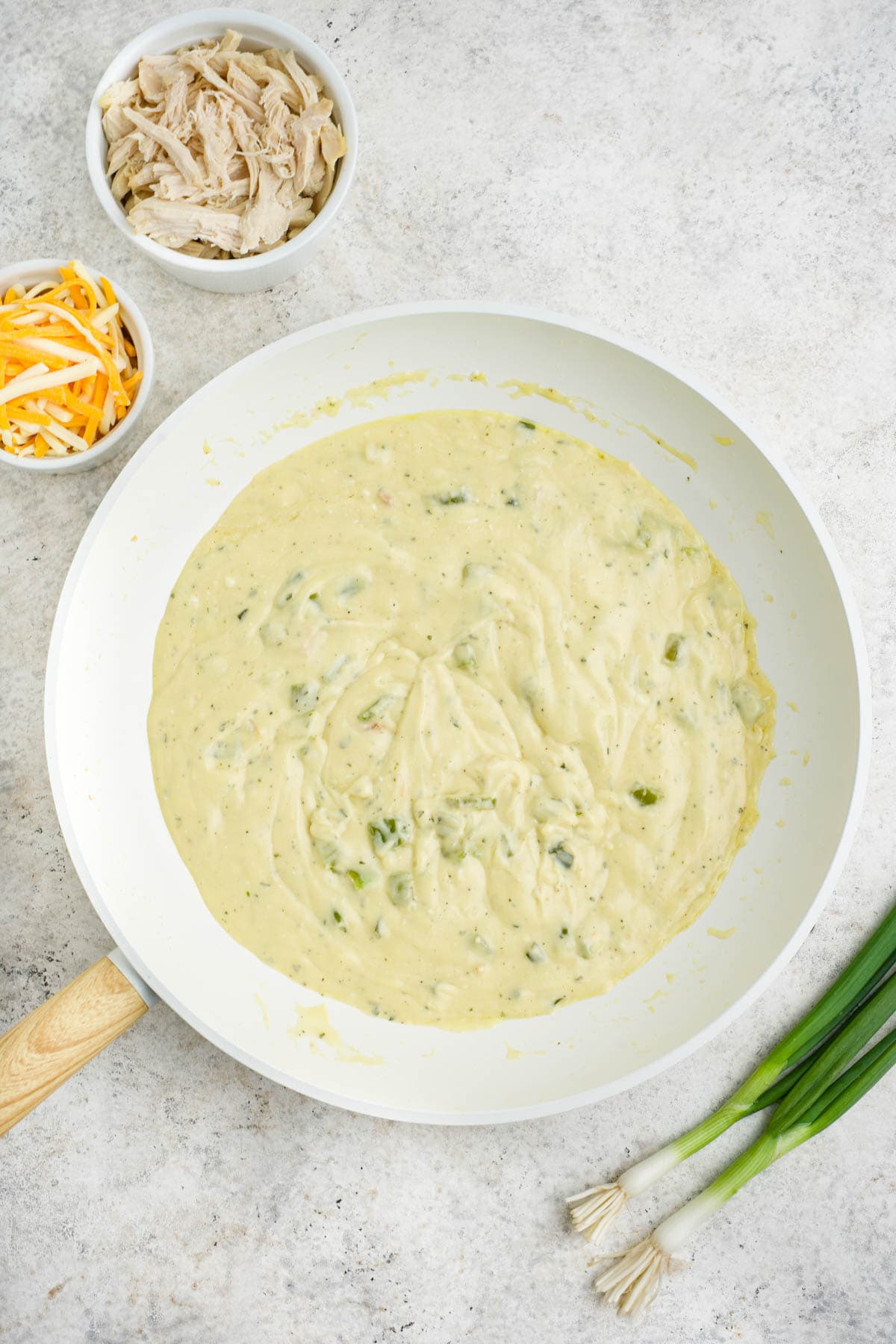 Cream soup adding to green onions in a skillet.