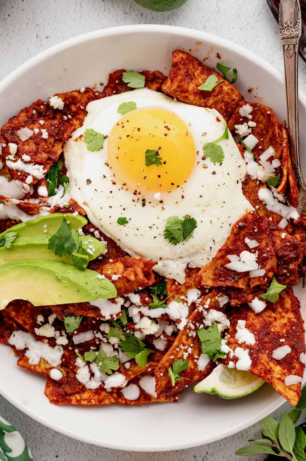 Chilaquiles Rojas topped with fried egg, avocado and cotija cheese.