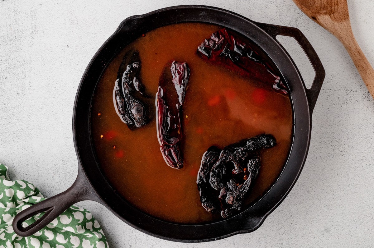 Chiles and liquid in a skillet.