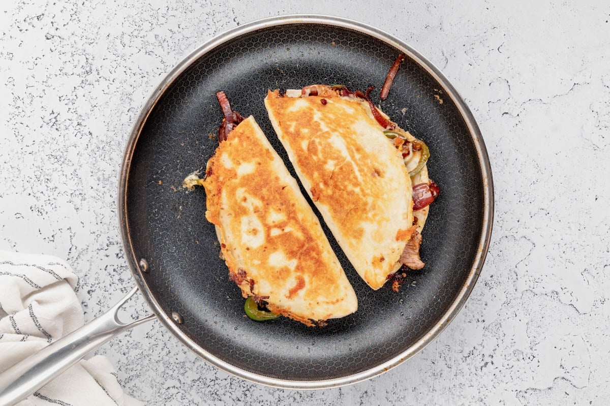 Quesadillas cooking in a large skillet.