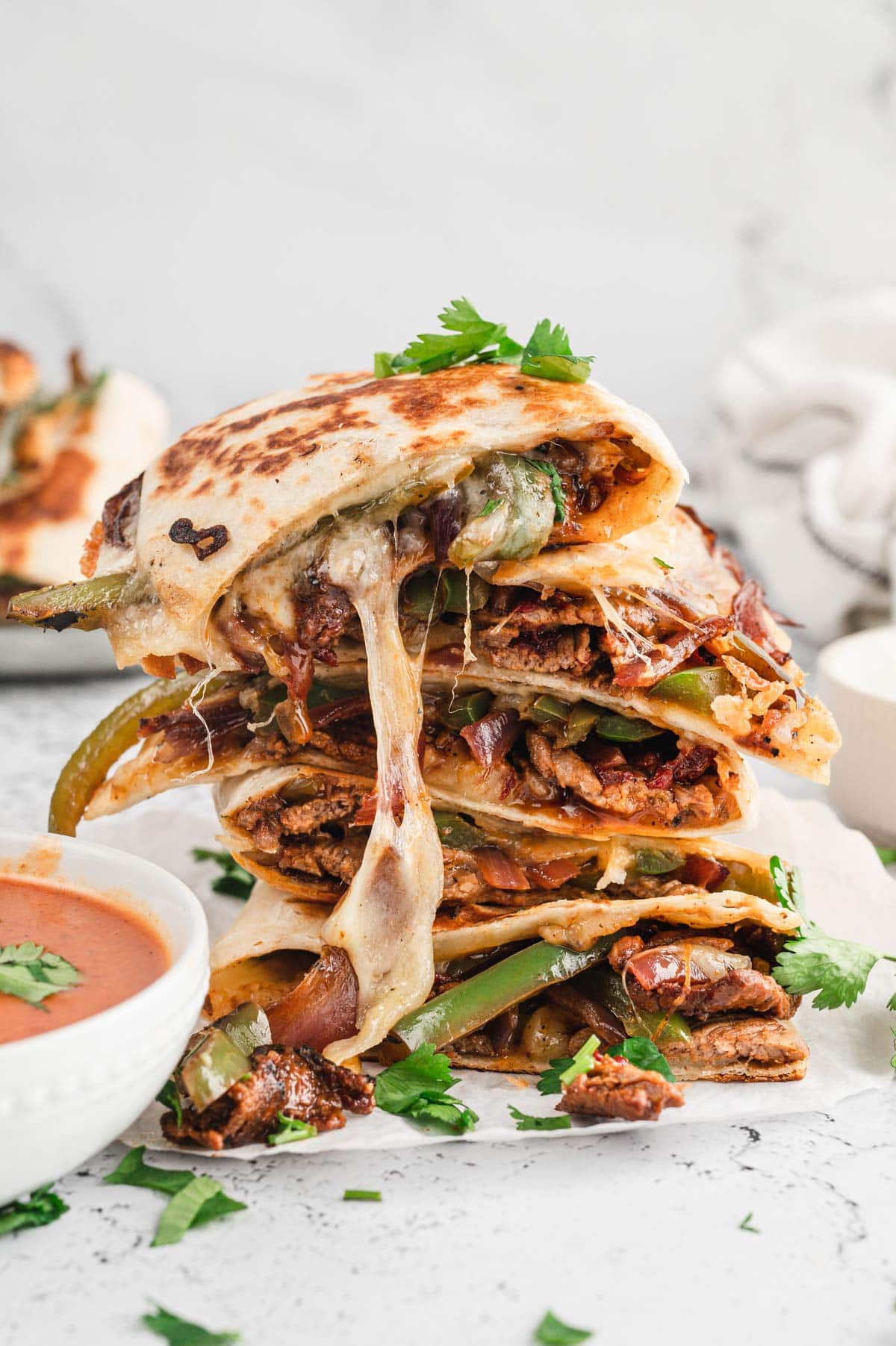 Cheesy steak quesadillas stacked on top of each other.