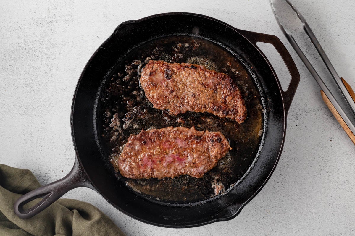 Cube steaks sauteed in a cast iron skillet.
