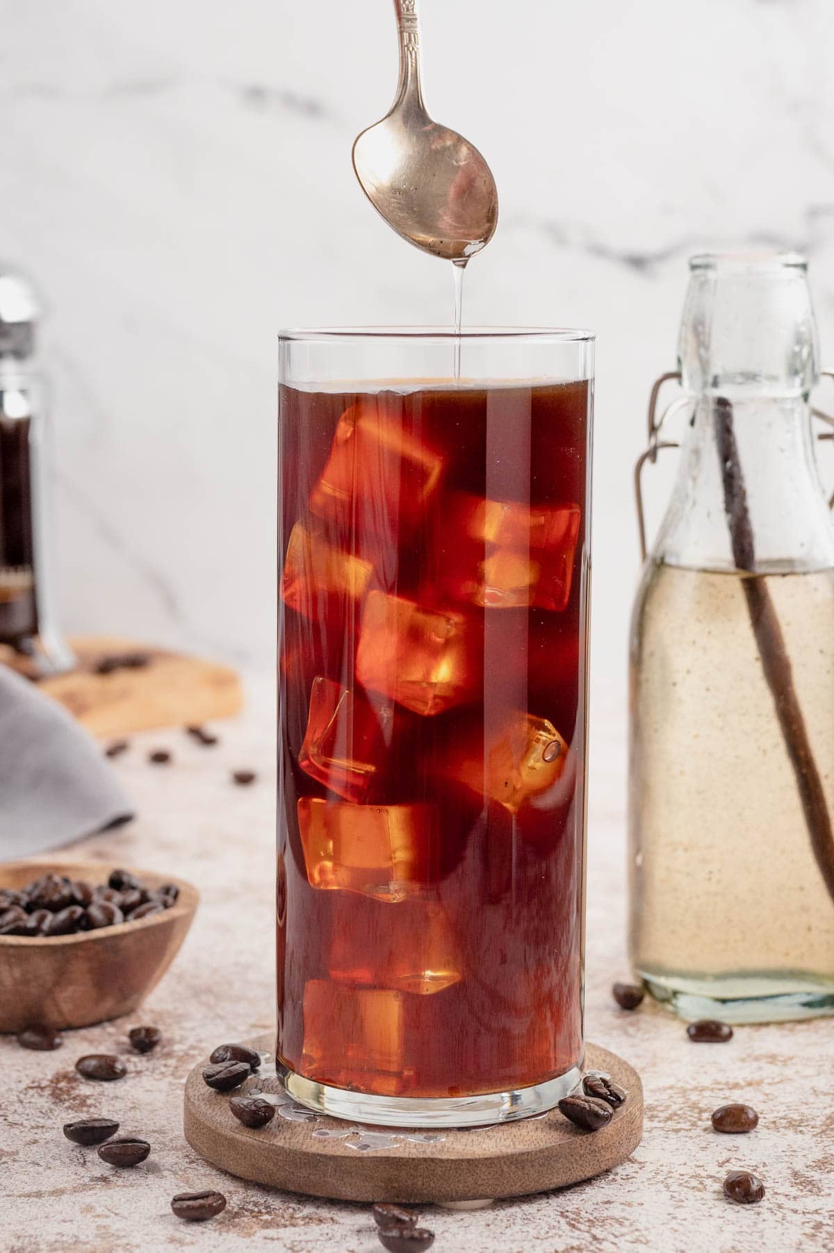 Coffee and iced cubes in a tall clear glass.