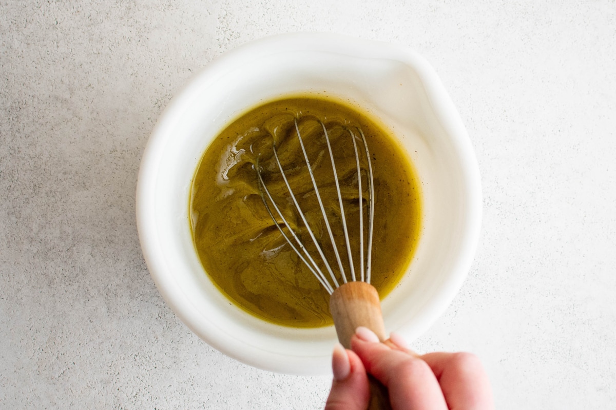 Vinaigrette in a bowl with a whisk.