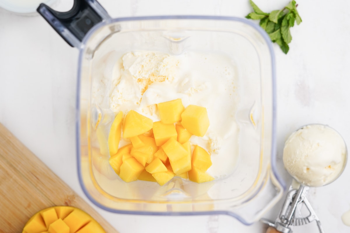 Mango, ice cream and milk in a blender.