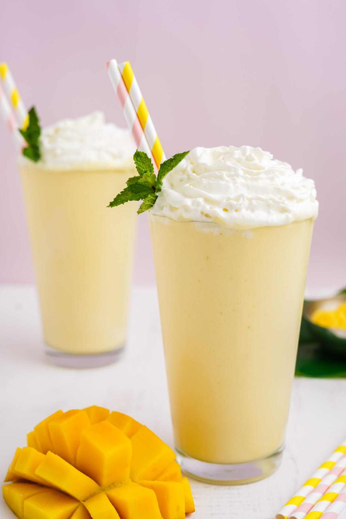 Mango milkshakes with whipped cream and straws