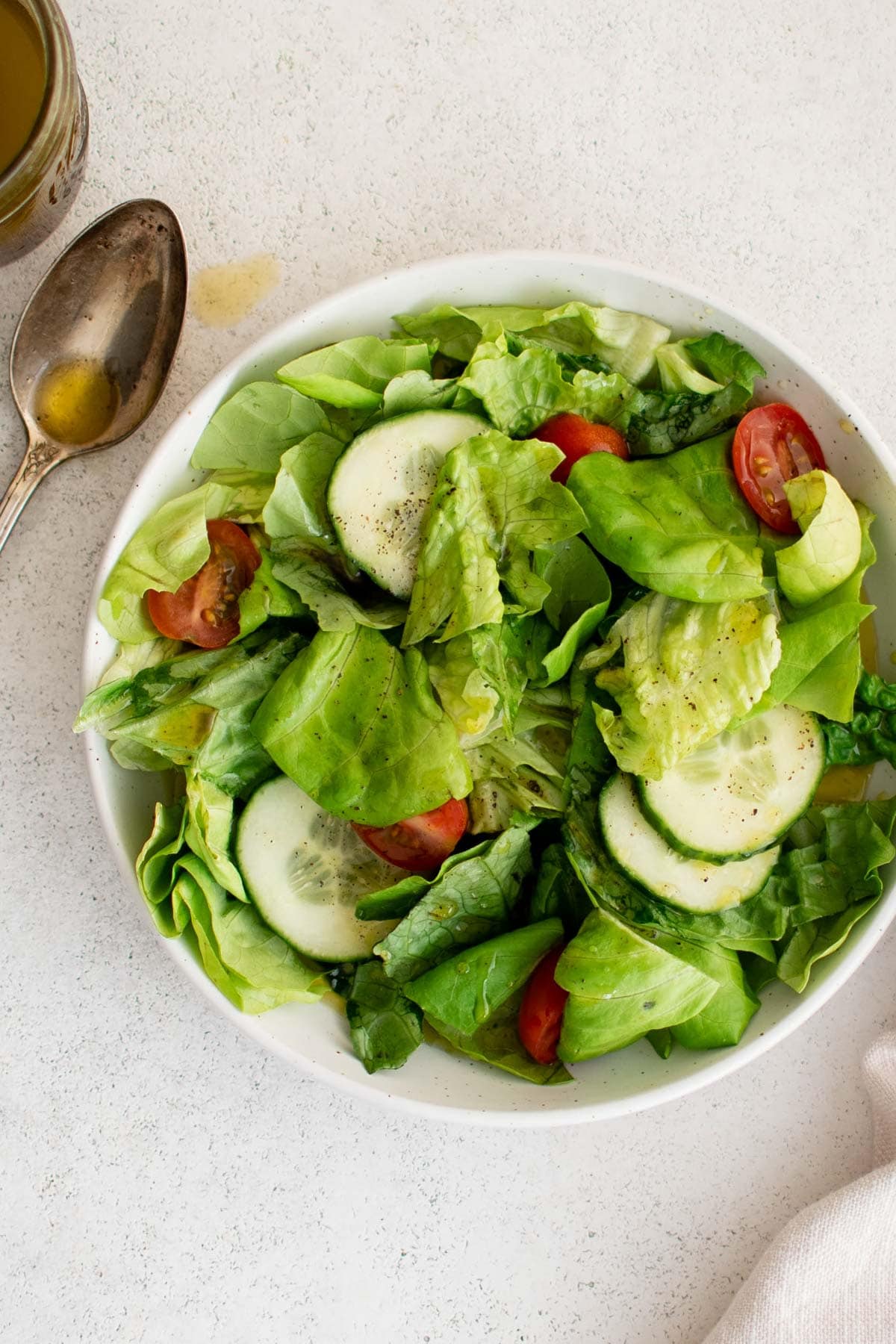 Small salad with cucumbers and tomatoes in a white bowl.
