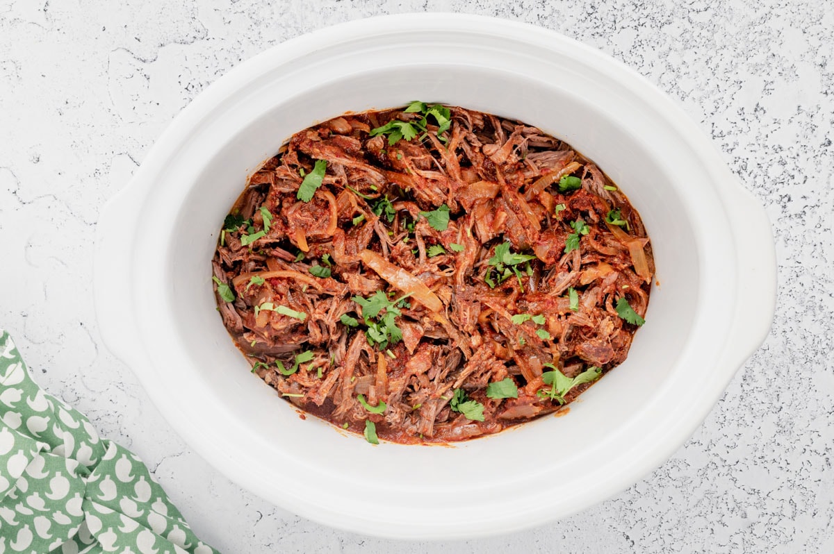 Shredded beef with cilantro in a slow cooker. 