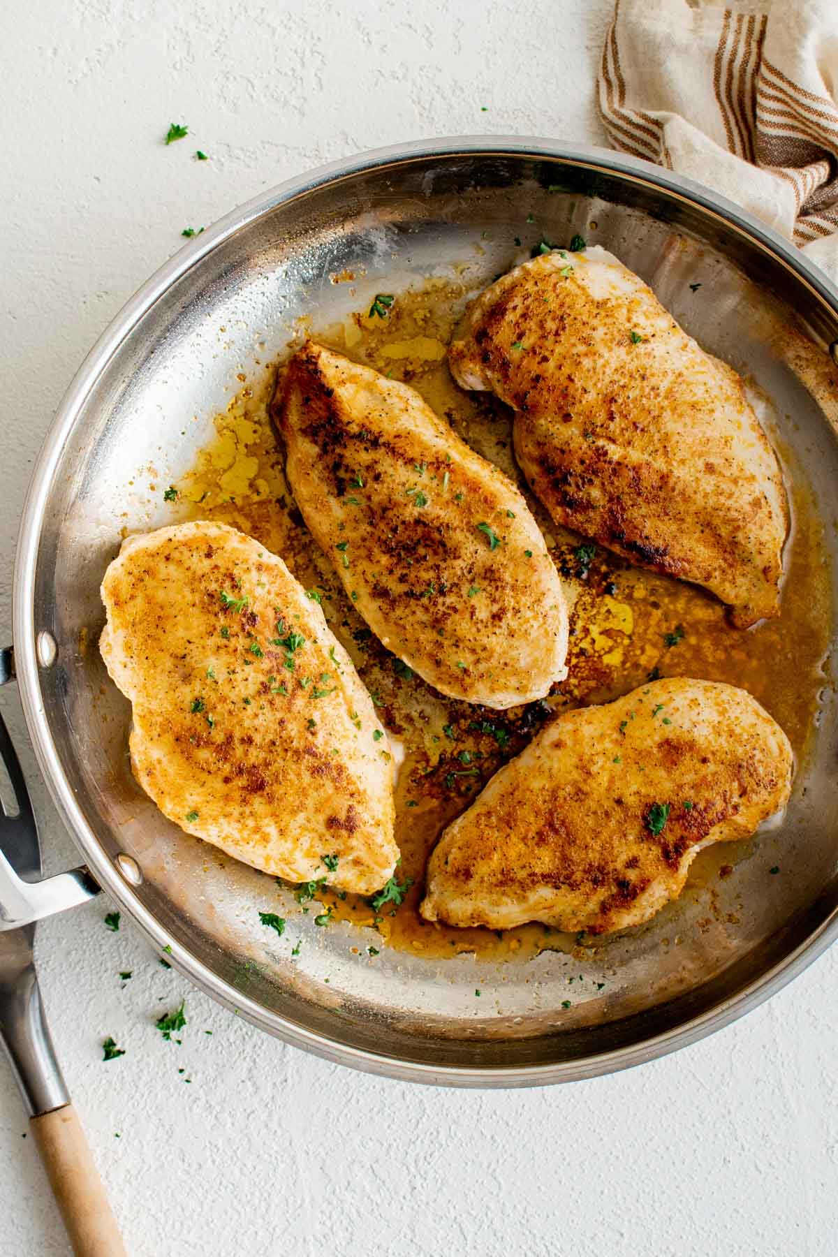 Pan seared stove top chicken breasts in a skillet.