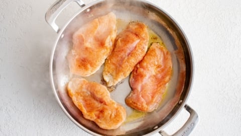 Chicken breasts in a skillet.
