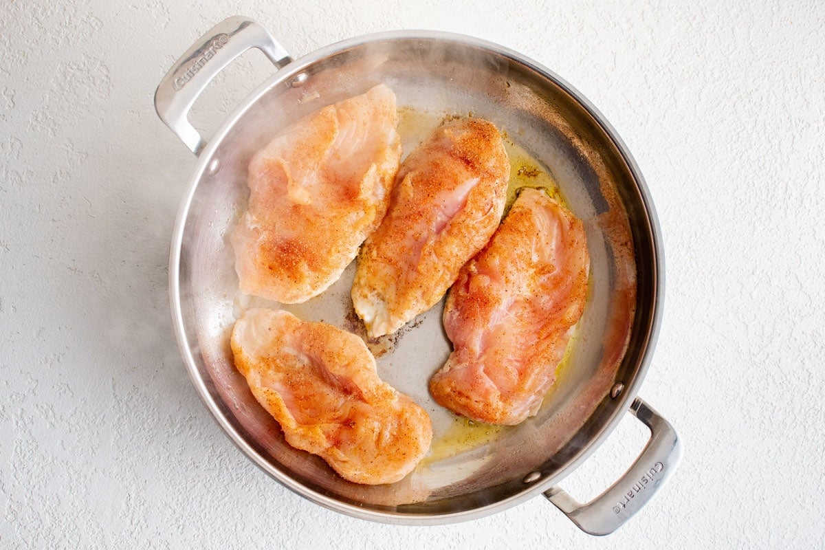 Chicken breasts in a skillet.