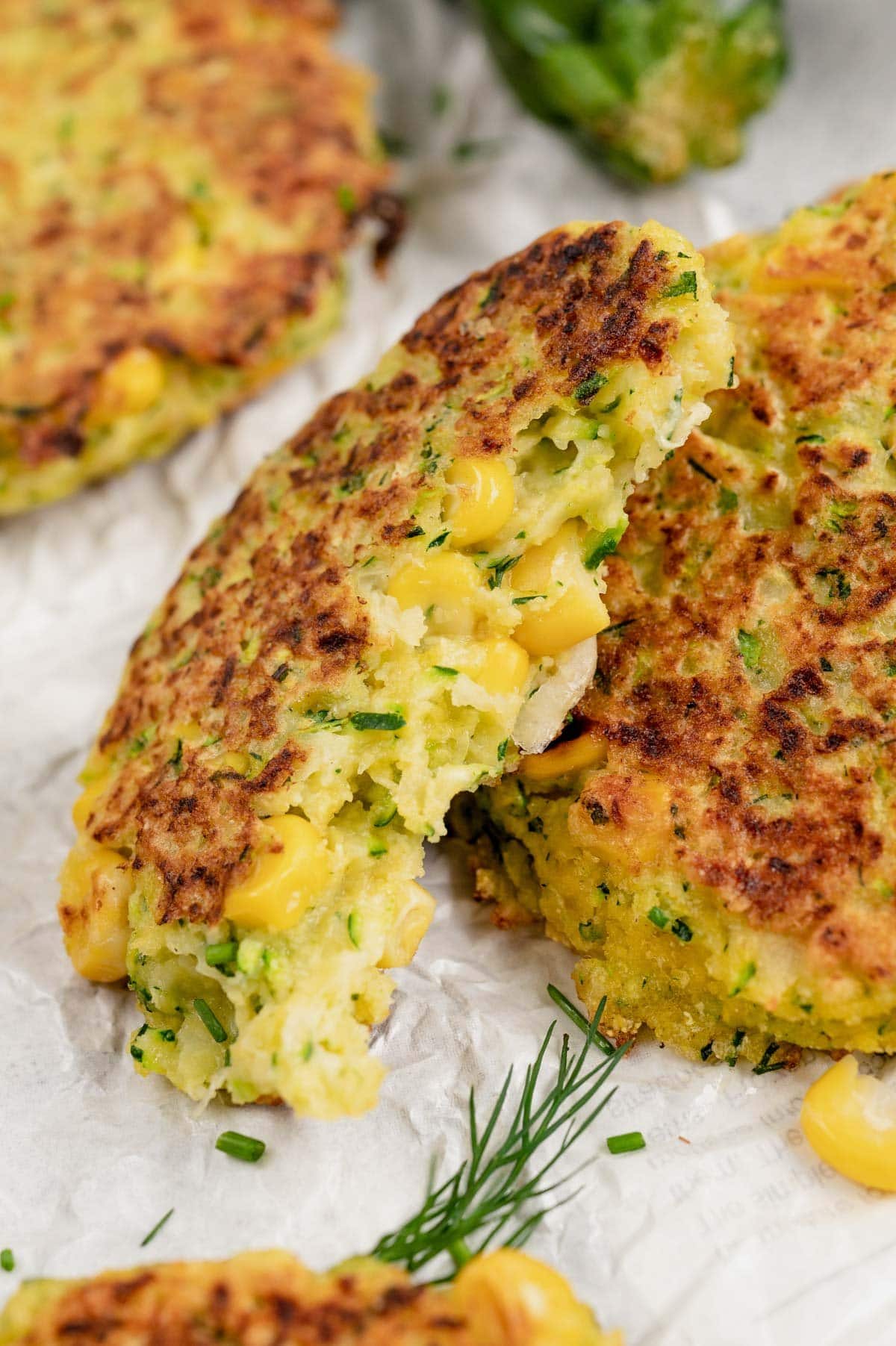 Zucchini corn fritter, split in half to show the inside.