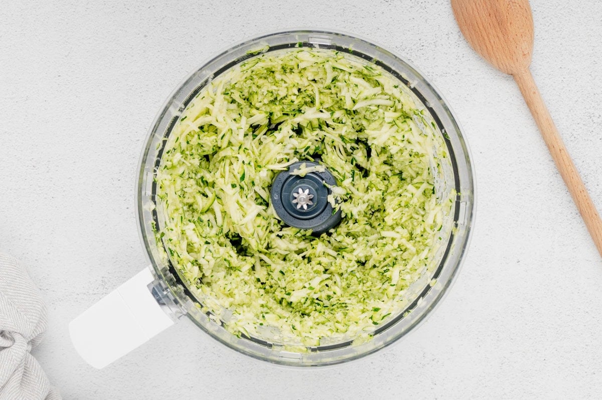 Shredded zucchini in a food processor.