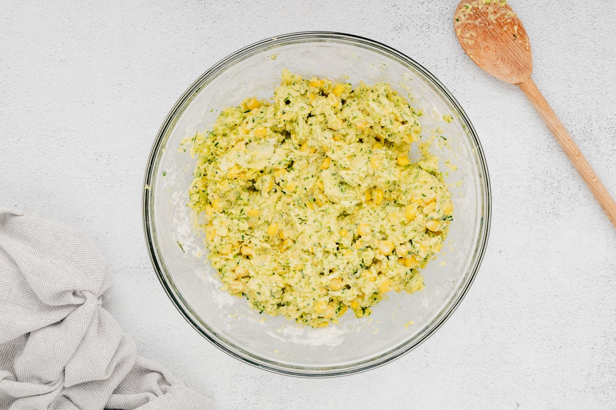 Shredded zucchini, corn and cornmeal batter in a large bowl. 