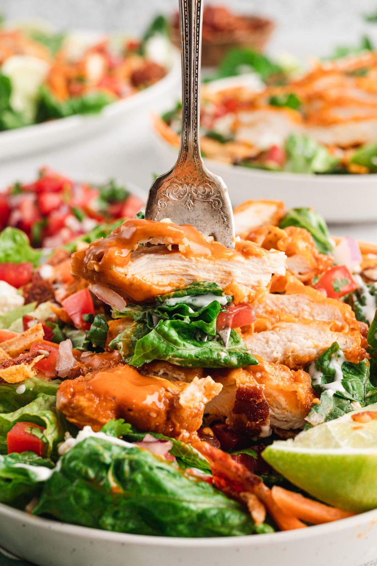 Buffalo chicken and salad on a fork.