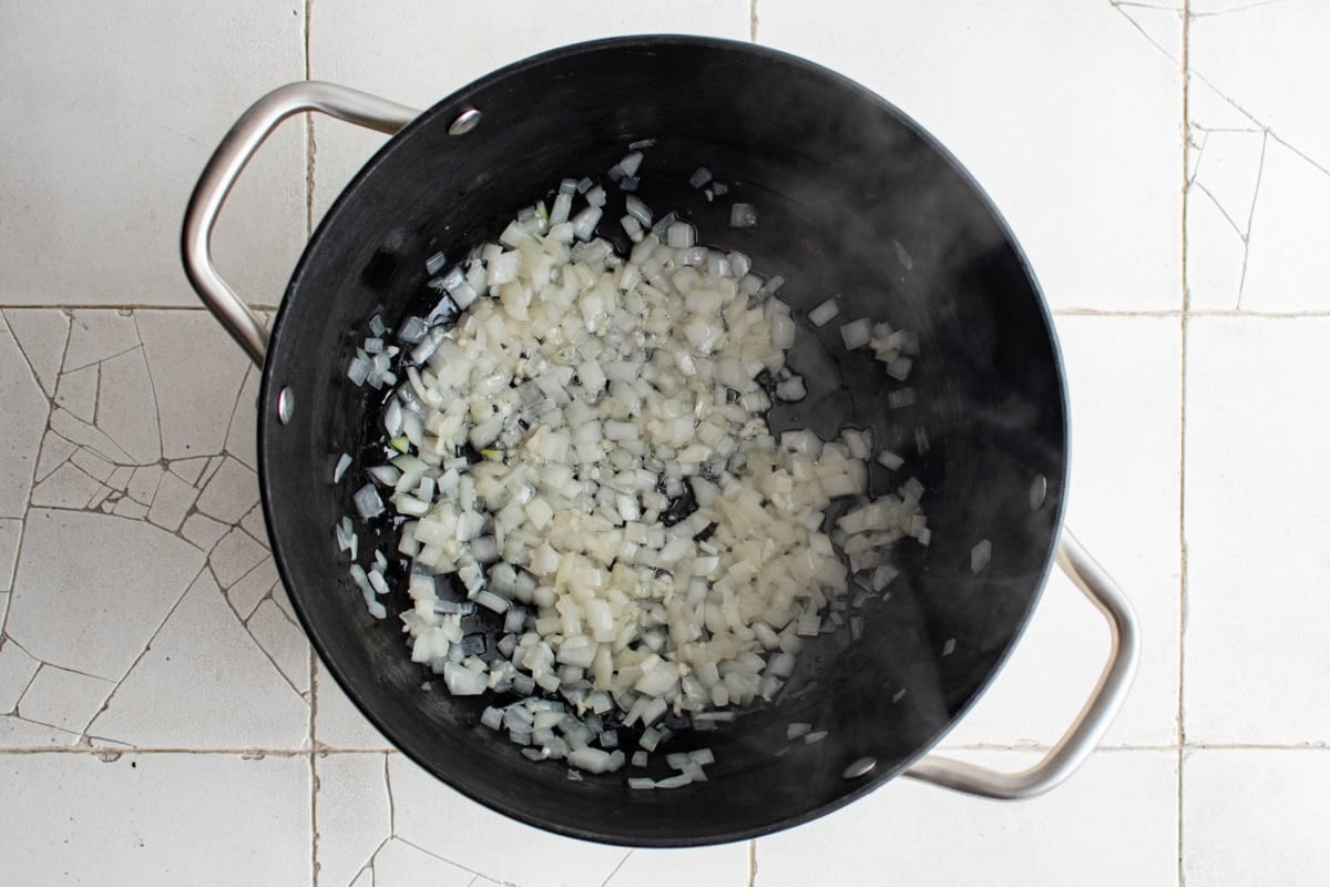 Chopped onion and minced garlic sauteed in a large pot.