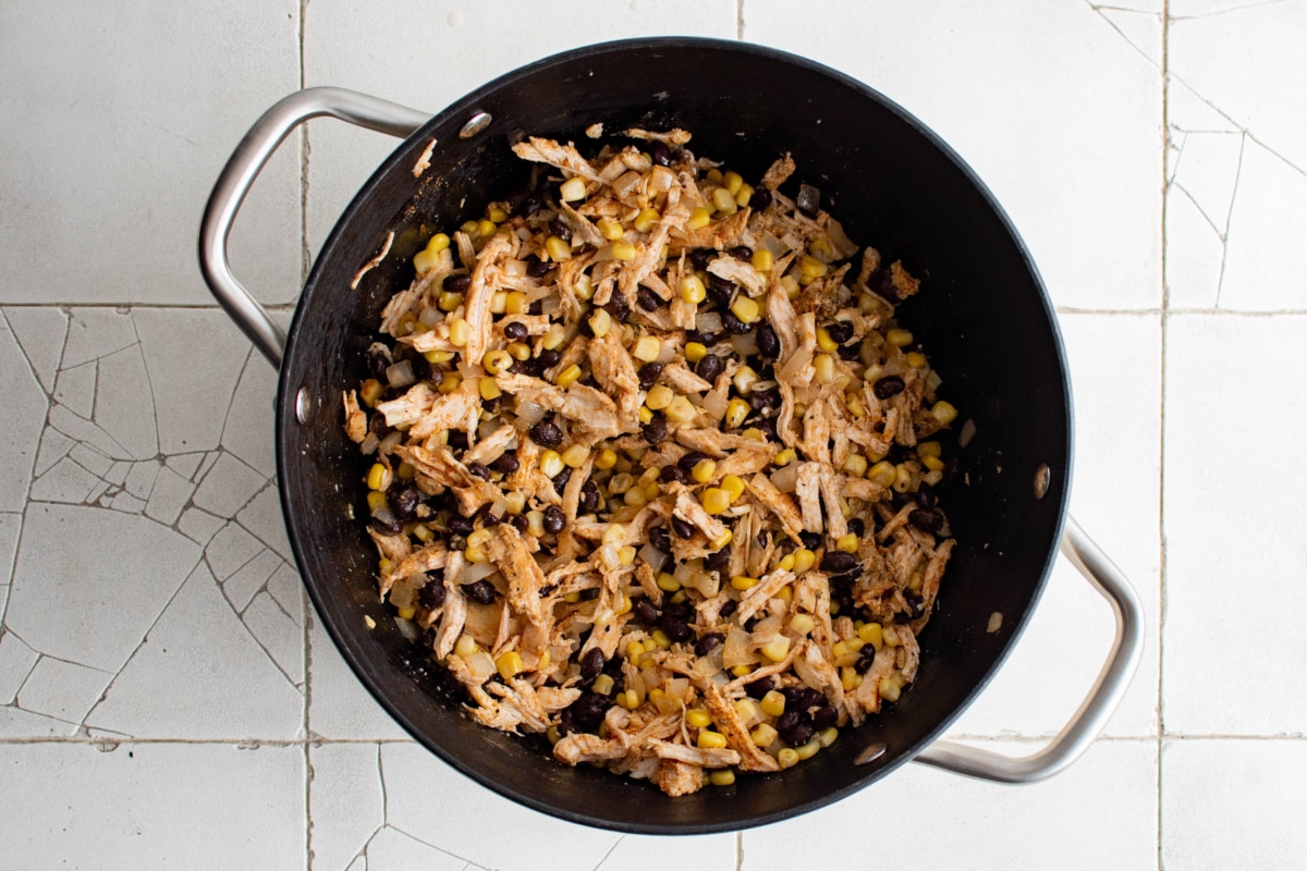 Mix of shredded chicken, corn, black beans in a large pot.