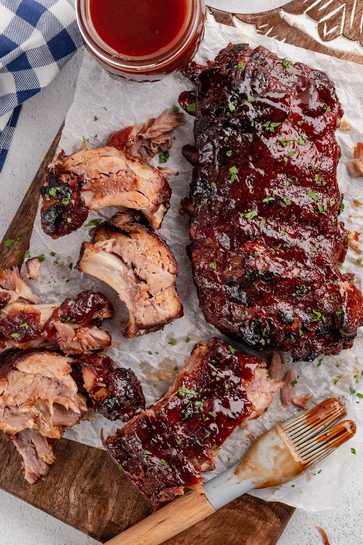 Cut up ribs on a baking sheet with bbq sauce.