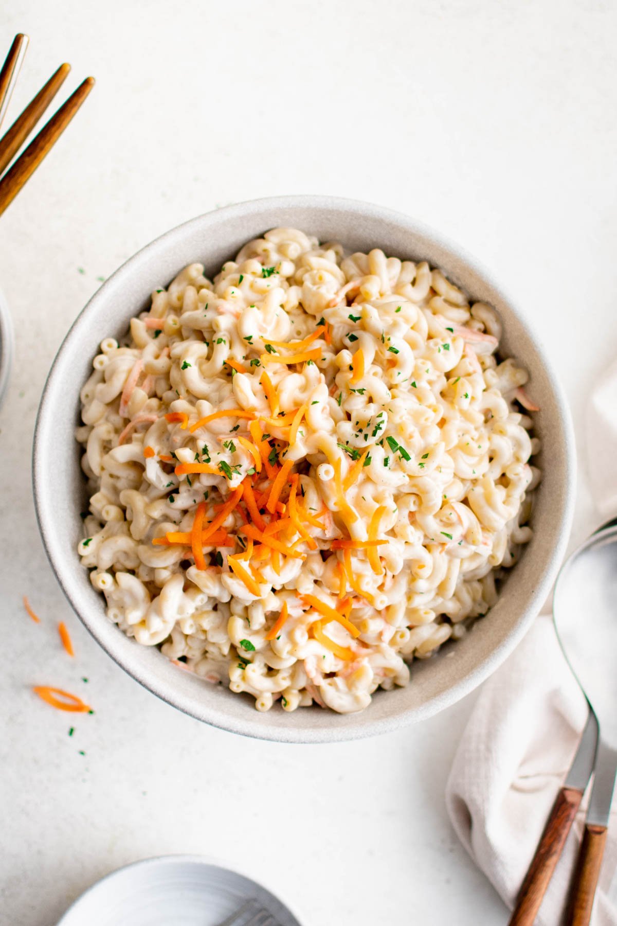 Creamy macaroni salad with shredded carrot on top.