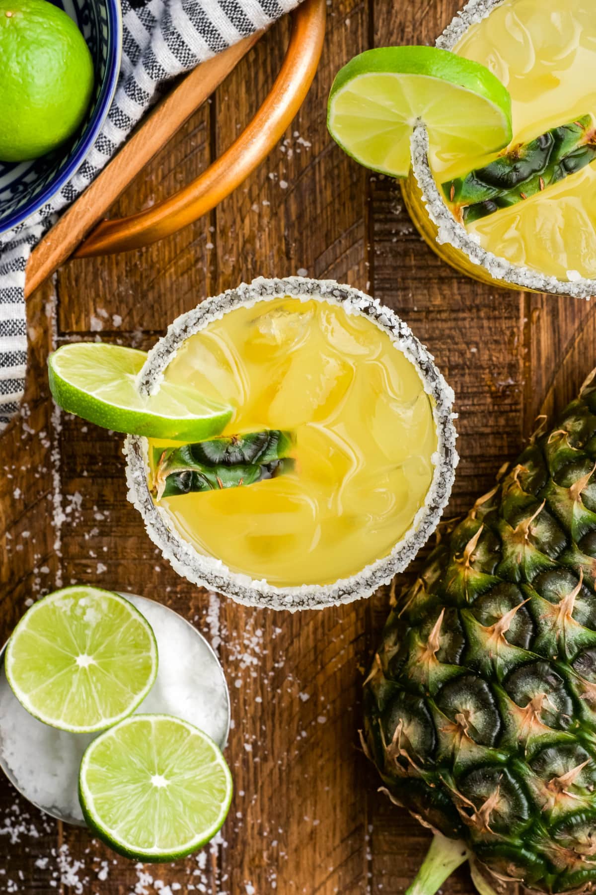 Overhead image of pineapple margaritas, limes and pineapple.