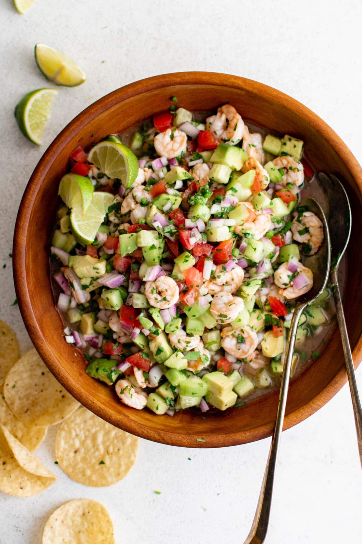 Shrimp Ceviche in a wooden bowl with metal serving spoons.